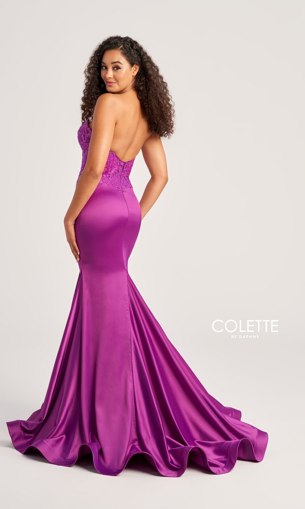 A woman wears the Strapless Colette Long Mermaid Prom Dress CL5116, featuring a beaded sweetheart bodice and fitted satin skirt, standing against a light background.